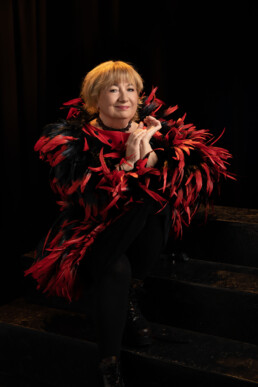 Seniorka w stylizacji burleskowej - czerwono czarne boa z piór
